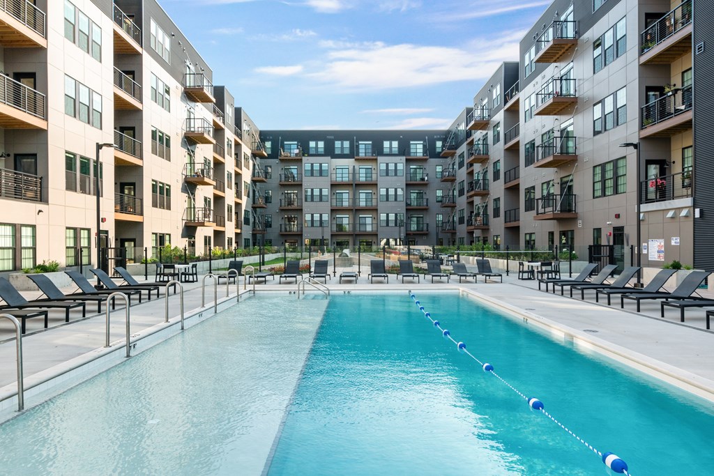 an apartment complex with a swimming pool in front of a building